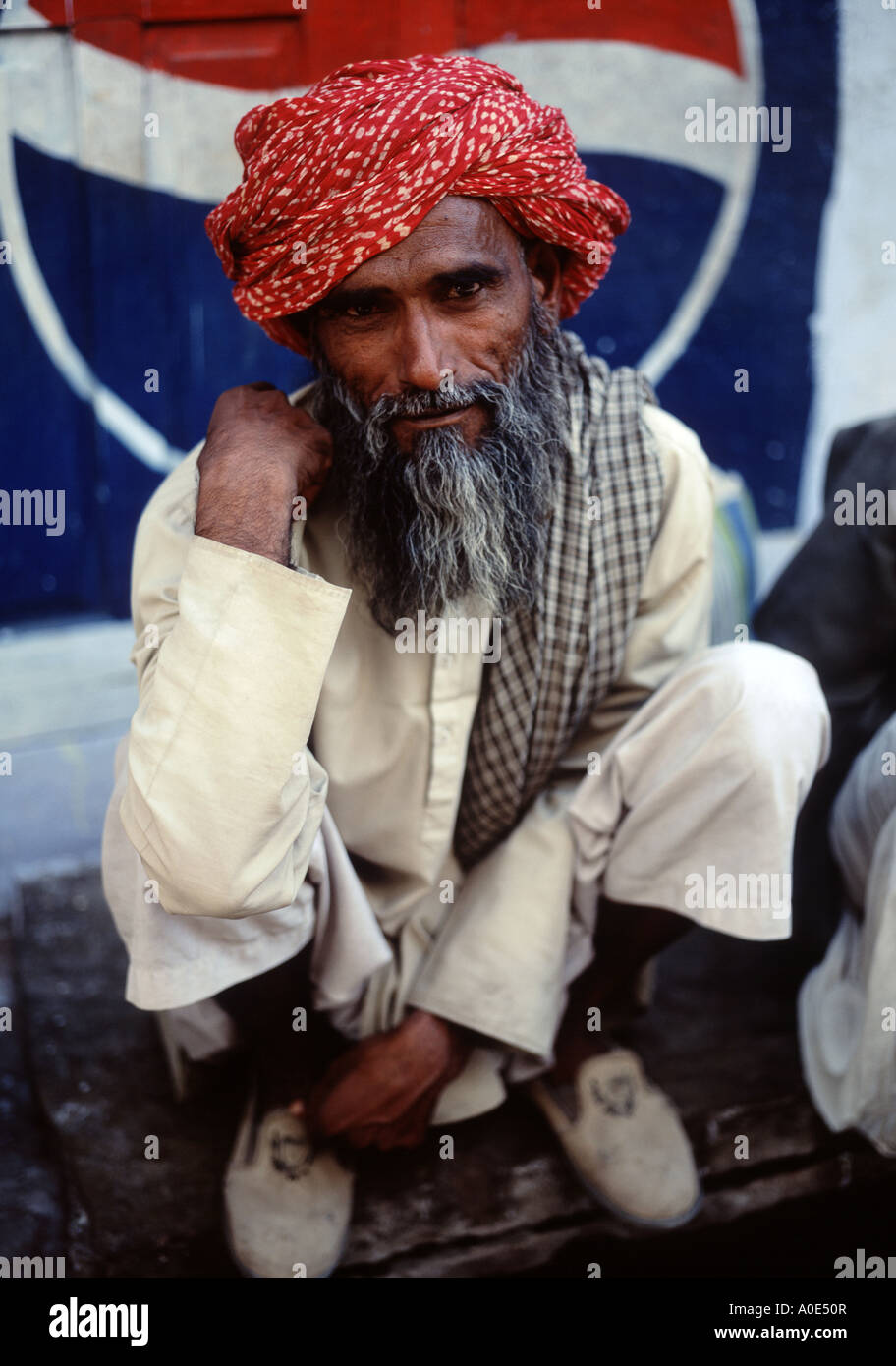 L'homme Indien assis devant signer Pepsi Banque D'Images