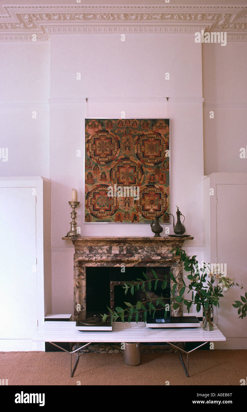 Photo au-dessus de la cheminée de marbre, des fleurs sur le tableau blanc moderne. Banque D'Images