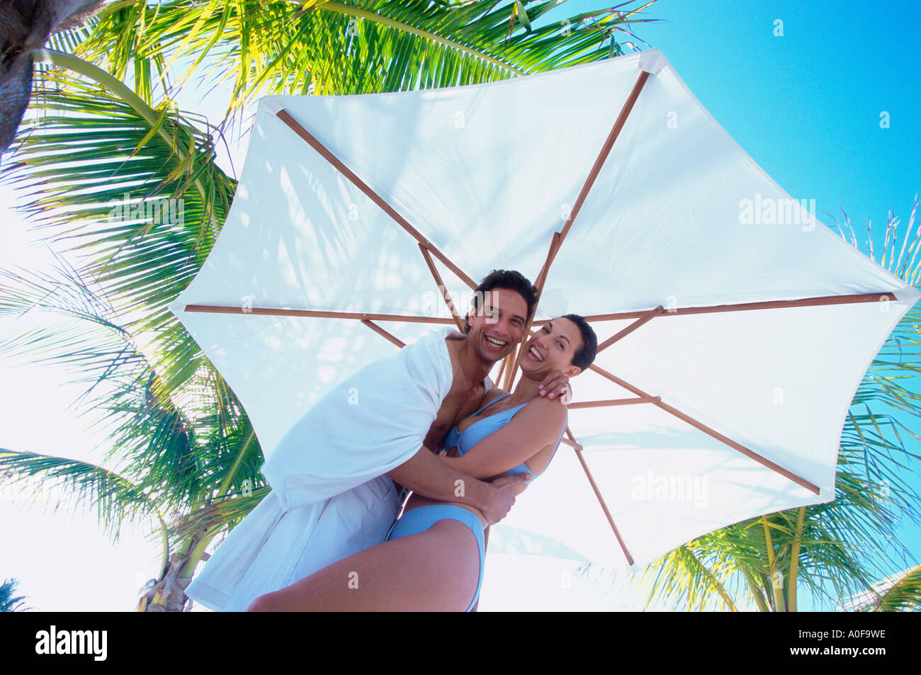 Portrait d'un jeune couple se tenant sous un parasol Banque D'Images