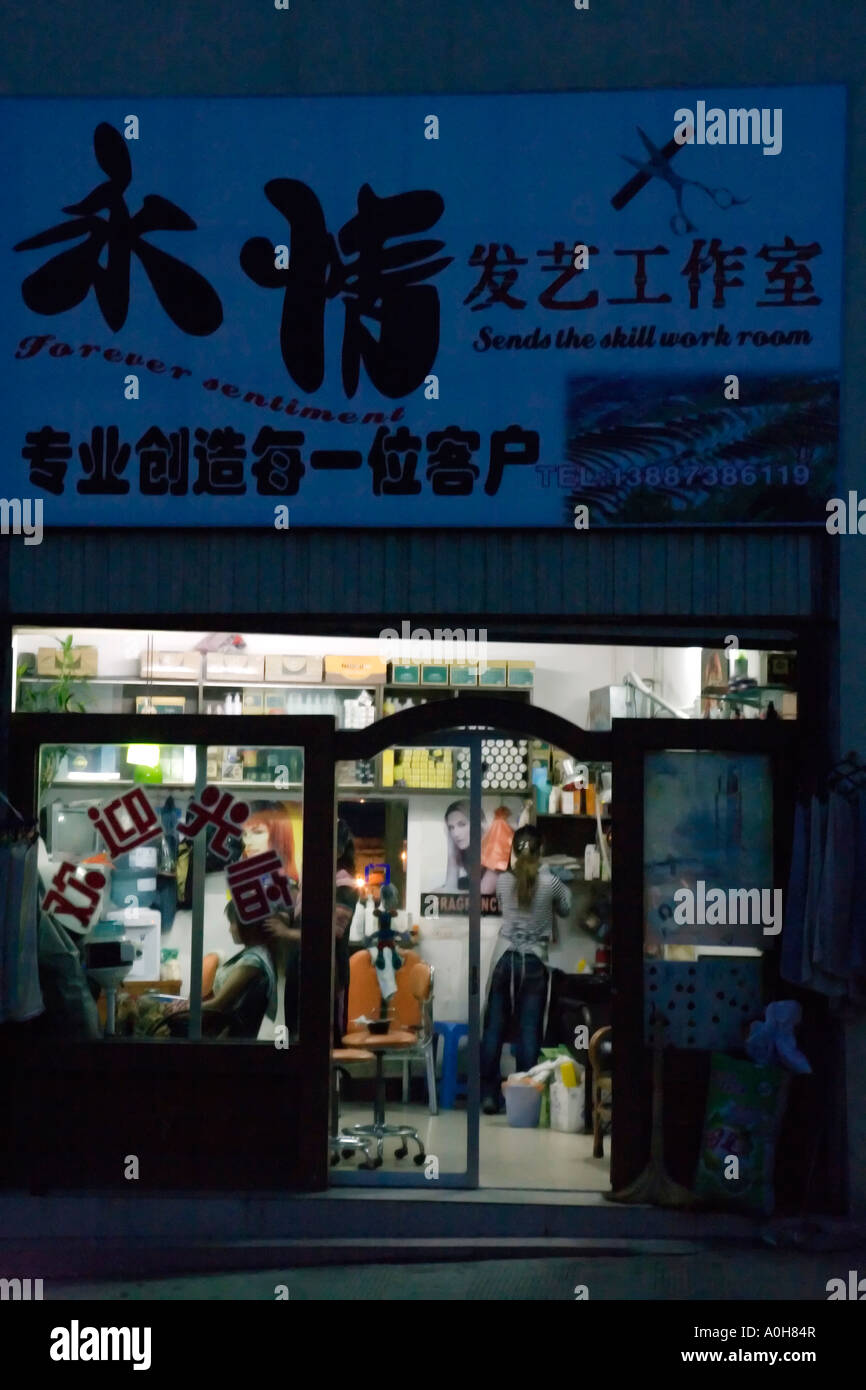 Fun affiches : Les sentiments 'Forever' salon de coiffure de nuit, village Xinjie, Yuanyang, Yunnan, Chine Banque D'Images