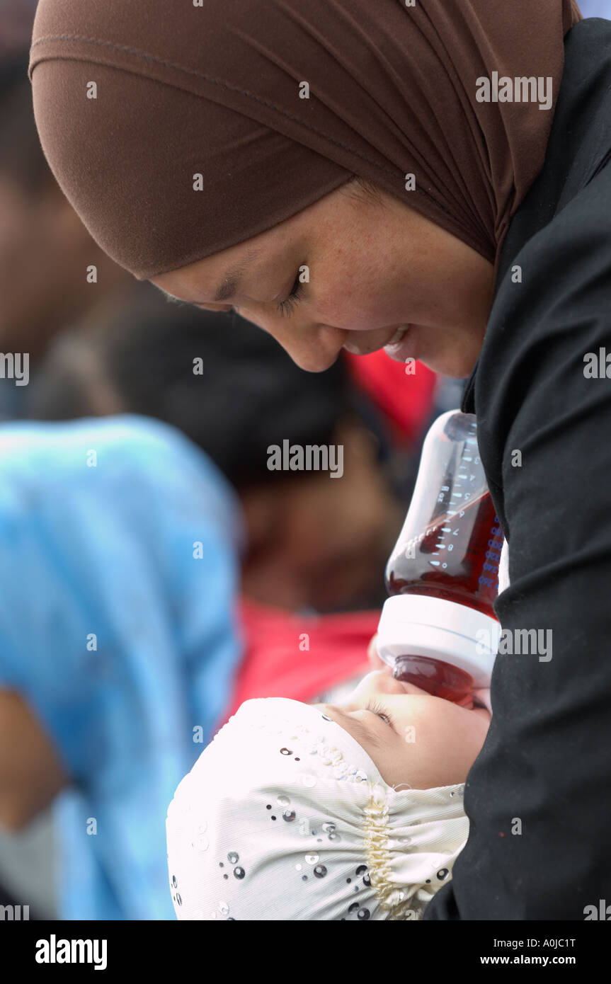 Femme musulmane biberon un bébé fille Banque D'Images