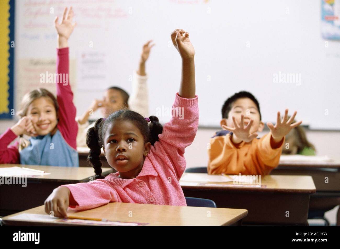 Les enfants de l'école lèvent la main dans la classe Banque D'Images