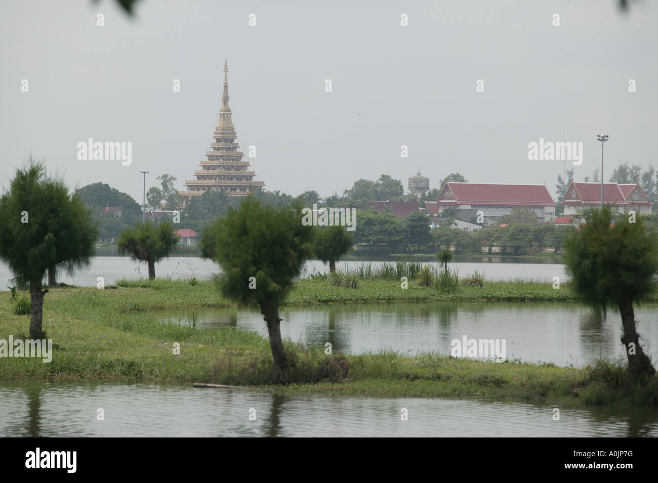 Wan Nong Muang temple voit de loin plus de champs inondés le Chedi contre un ciel gris pluvieux terne à Khon Kaen Banque D'Images