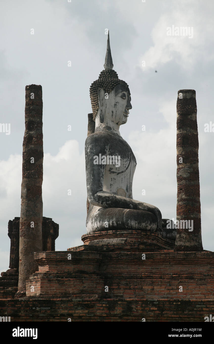 Grand Bouddha et certains des 200 ruiné surtout dans le Khumer Chedis en brique et de style ceylanais contre un ciel gris et terne au Wat Phra Si Ratana Mahathat temple à Sukhothai Banque D'Images