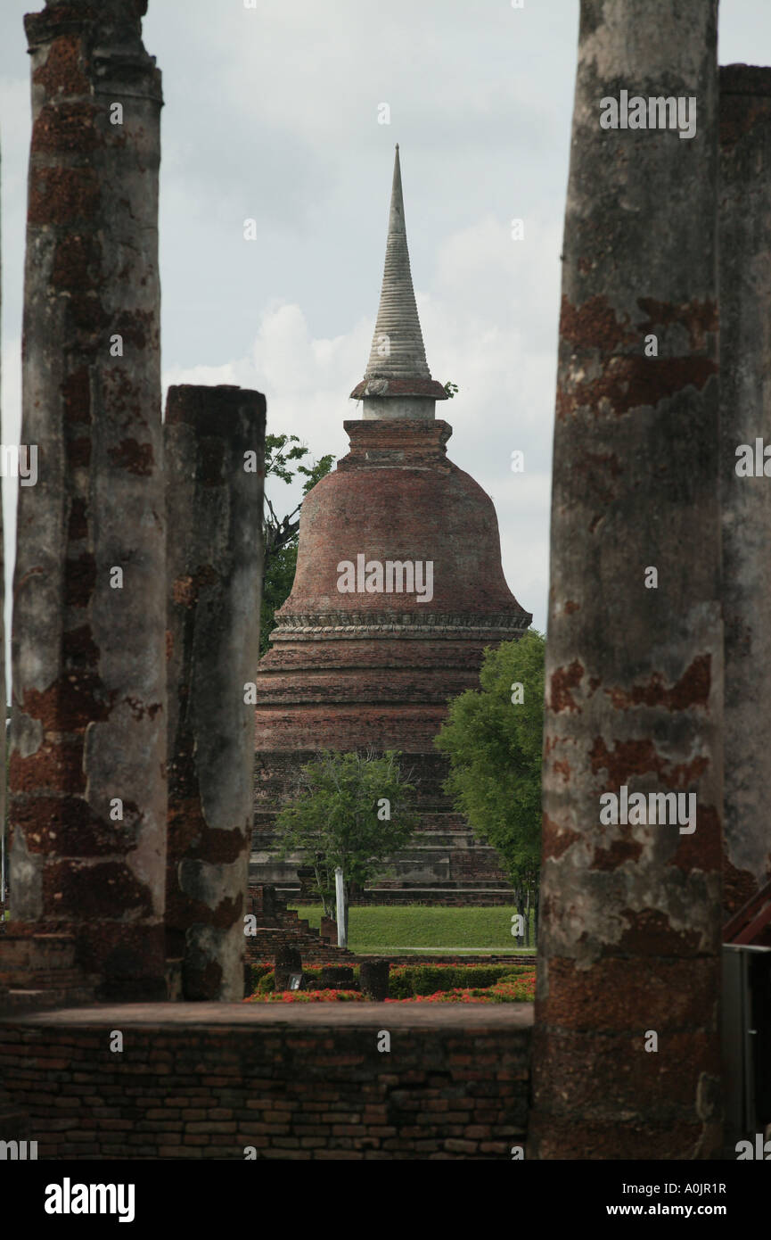 Vue entre les piliers l'un des 200 ruiné surtout dans le Khumer Chedis en brique et de style ceylanais contre un ciel gris et terne au Wat Phra Si Ratana Mahathat temple à Sukhothai Banque D'Images