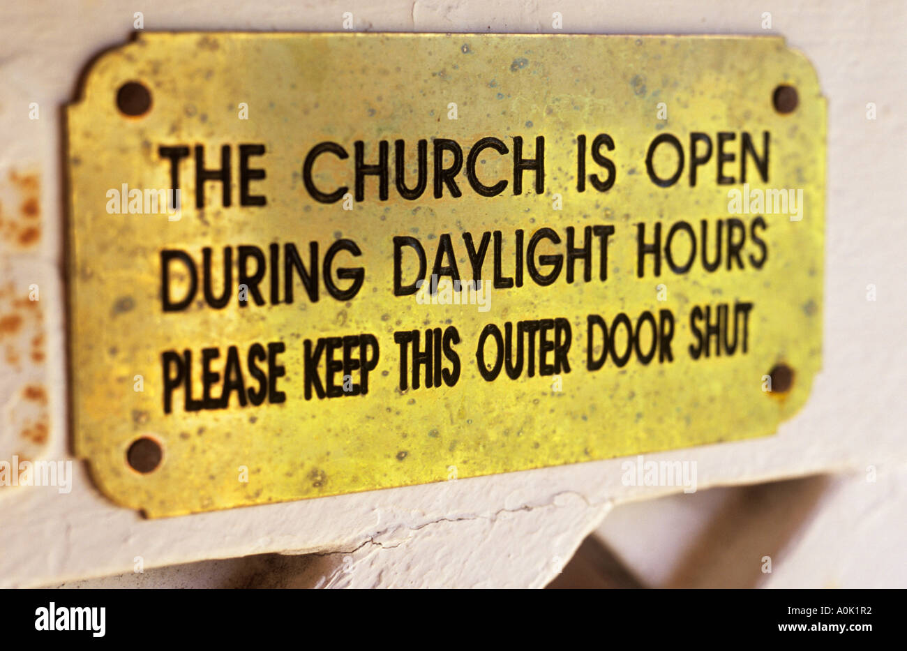 Close up de plaque en laiton fixée à la porte de l'écran indiquant l'église est ouverte pendant les heures de jour Veuillez garder cette porte extérieure fermer Banque D'Images