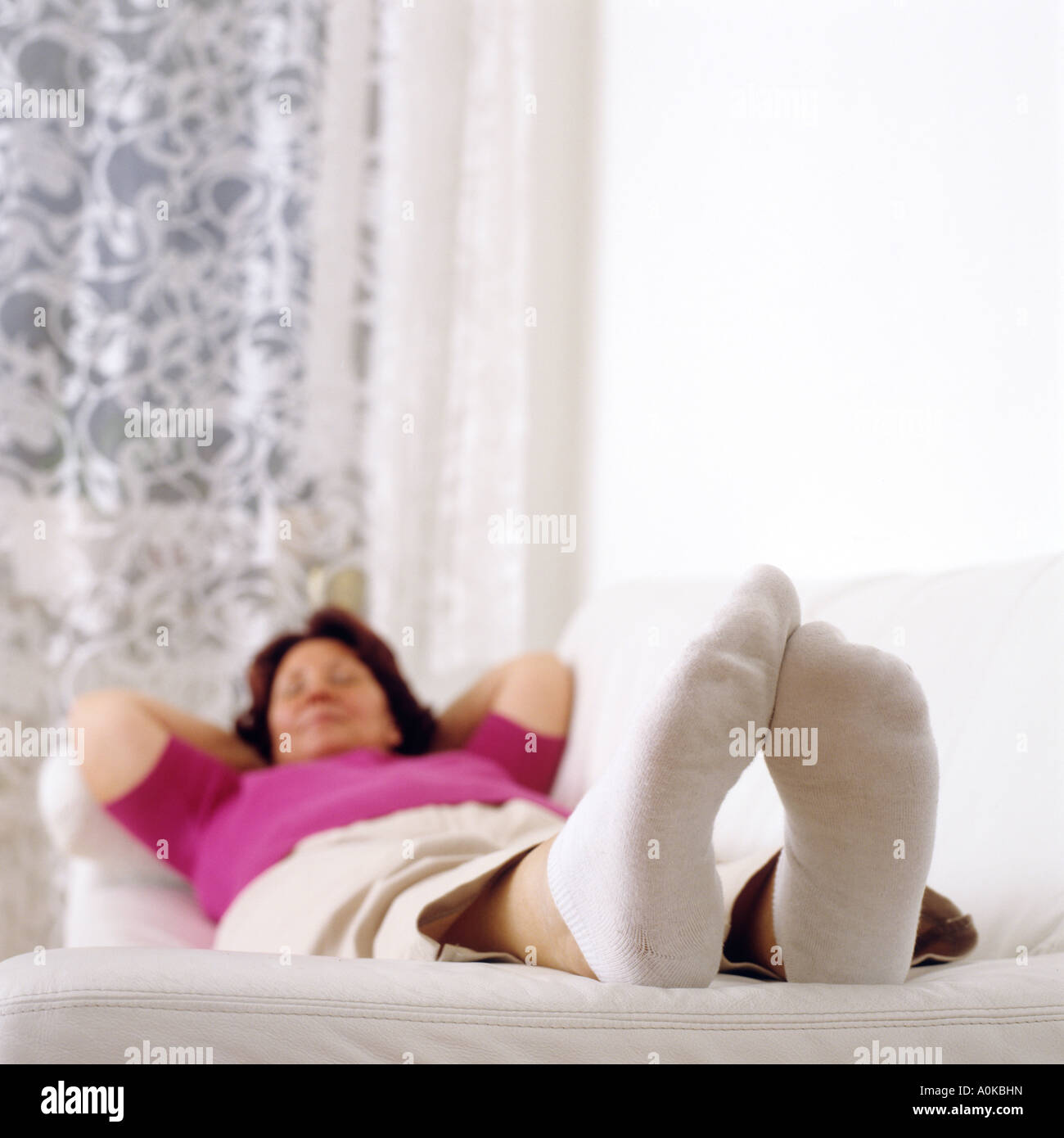 Young woman relaxing on sofa confortablement Banque D'Images