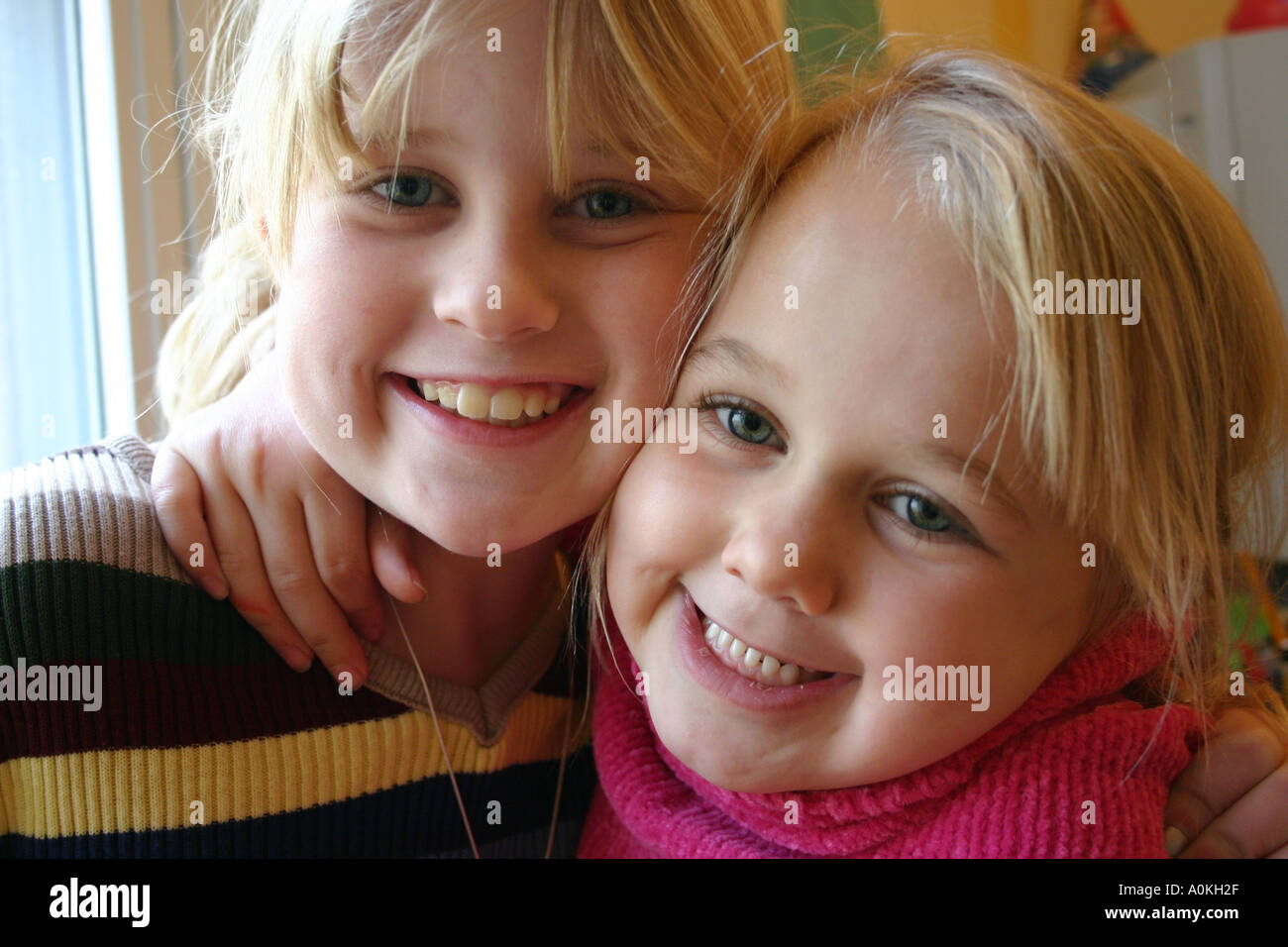 Sisters hugging and smiling Banque D'Images