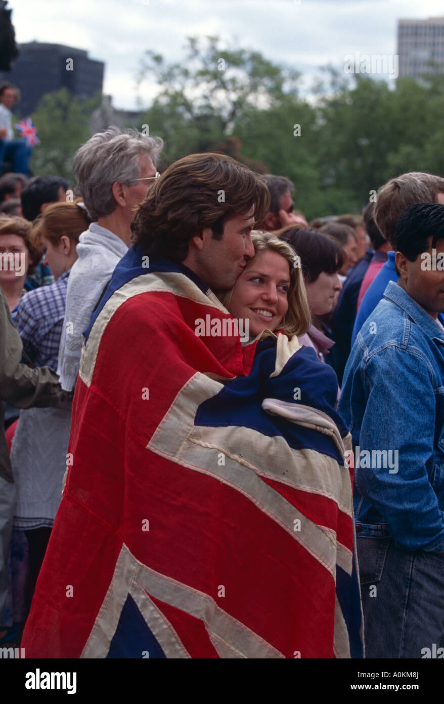 Un couple aimant enveloppé dans une Union Jack à l'extérieur de Buckingham Palace à la célébration du Jubilé de Londres en juin 2002 Banque D'Images