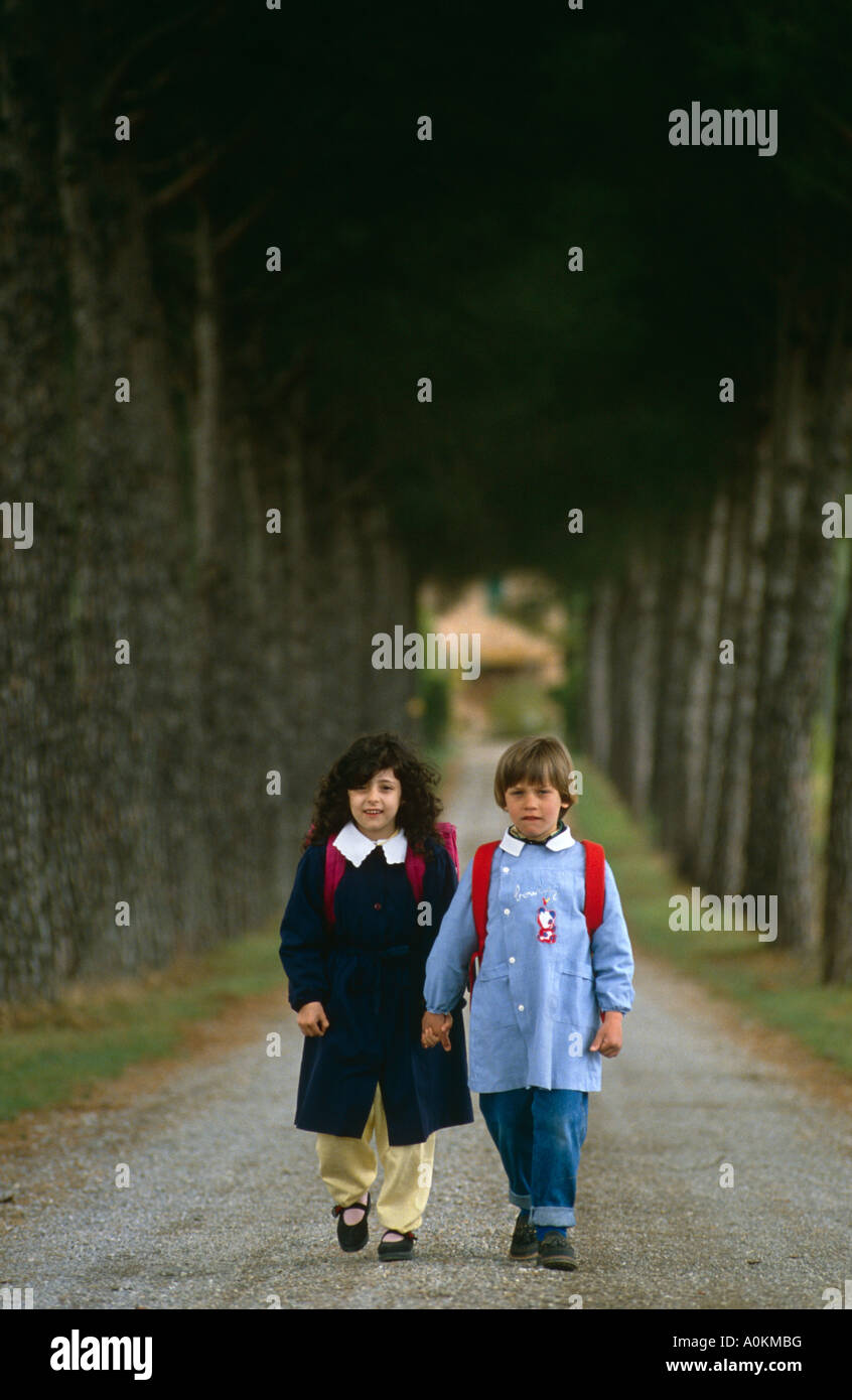 Deux enfants sur le chemin de l'école en uniforme, dans la région de Chiusi, Ombrie, Italie Banque D'Images