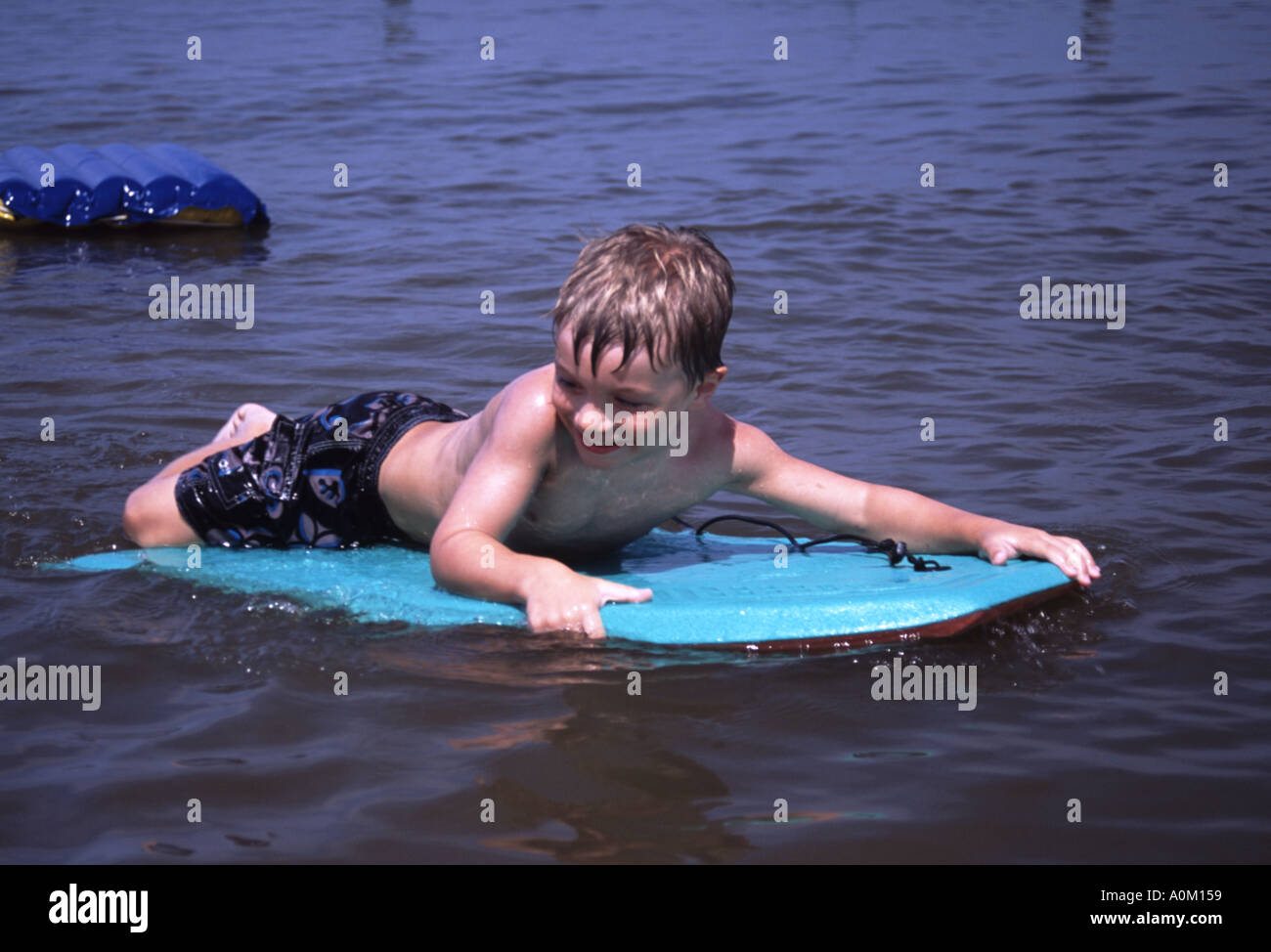 Jeune garçon sur une planche de surf dans l'eau à Breezy Point Maryland USA Banque D'Images