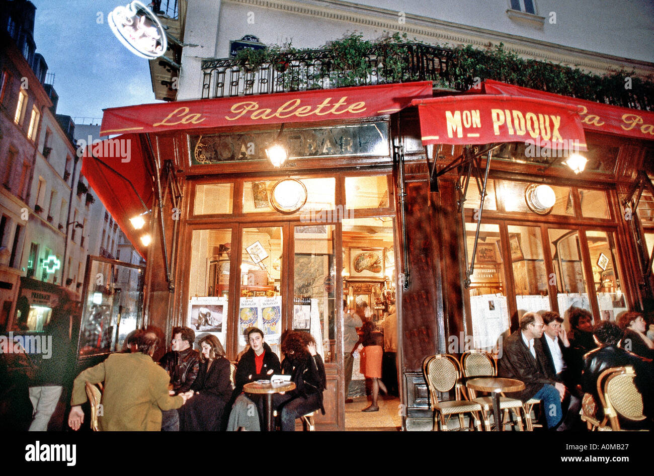 Groupe personnes partageant des boissons, boire un café-bar dans les cafés français, PARIS France, terrasse sur le trottoir au café 'la Palette' la nuit, Paris café cocktails, Banque D'Images