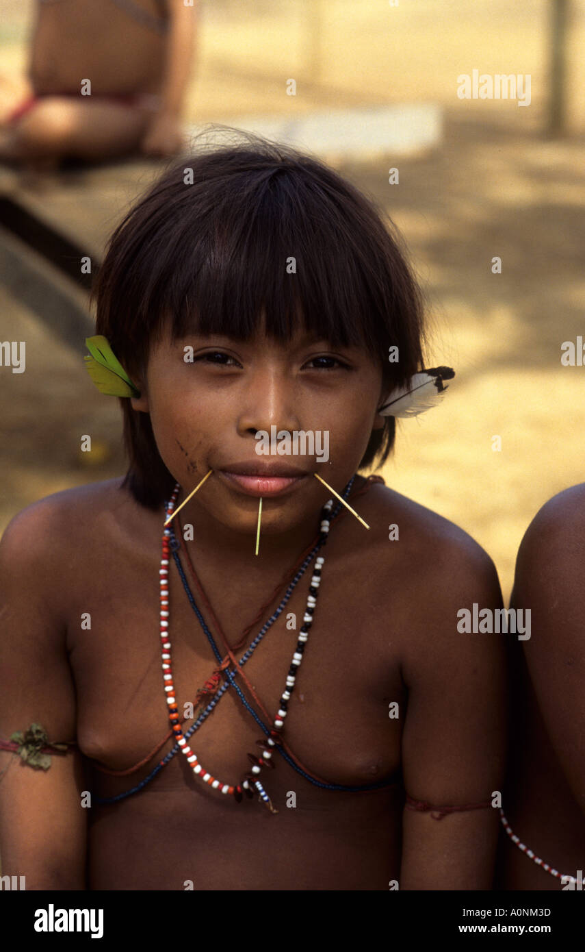 L'État de Roraima, Paapiu, au Brésil. Fille avec des Indiens yanomamis percés bouche ornée de tiges de bambou fendu, décorations de l'oreille de plumes Banque D'Images