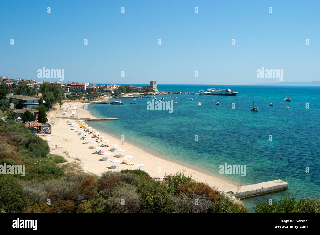 Vue sur la plage et de la ville avec la tour byzantine dans la distance, Ouranopolis, péninsule Athos, Halkidiki, Grèce Banque D'Images