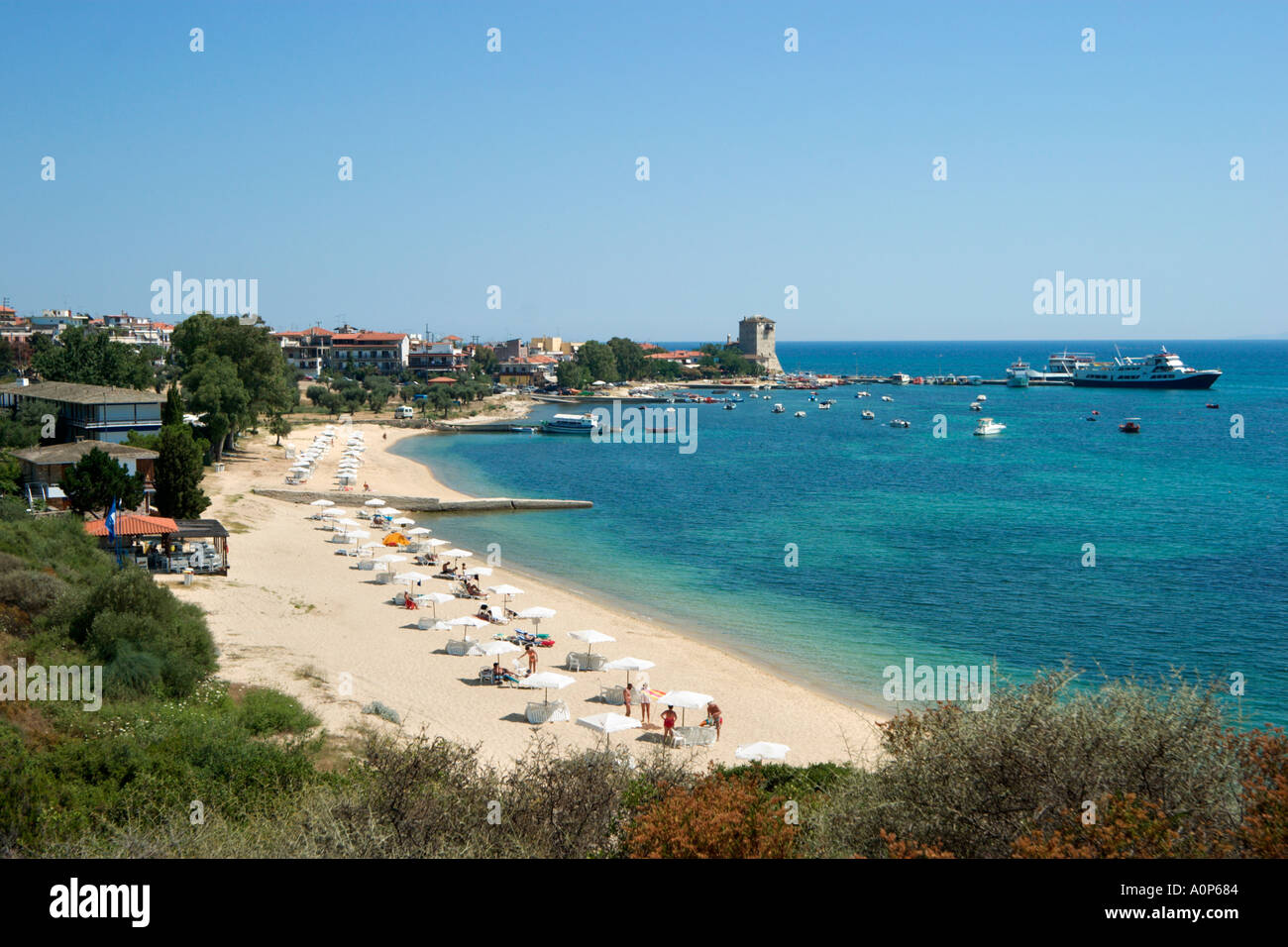 Vue sur la plage et de la ville avec la tour byzantine dans la distance, Ouranopolis, péninsule Athos, Halkidiki, Grèce Banque D'Images