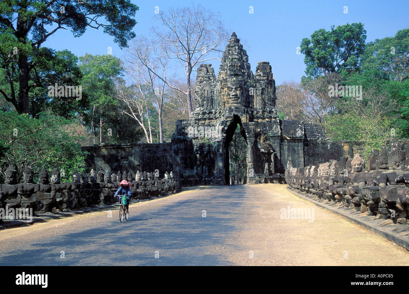 Femme monter sur son vélo à l'entrée sud d'Angkor Thom Angkor Cambodge Banque D'Images