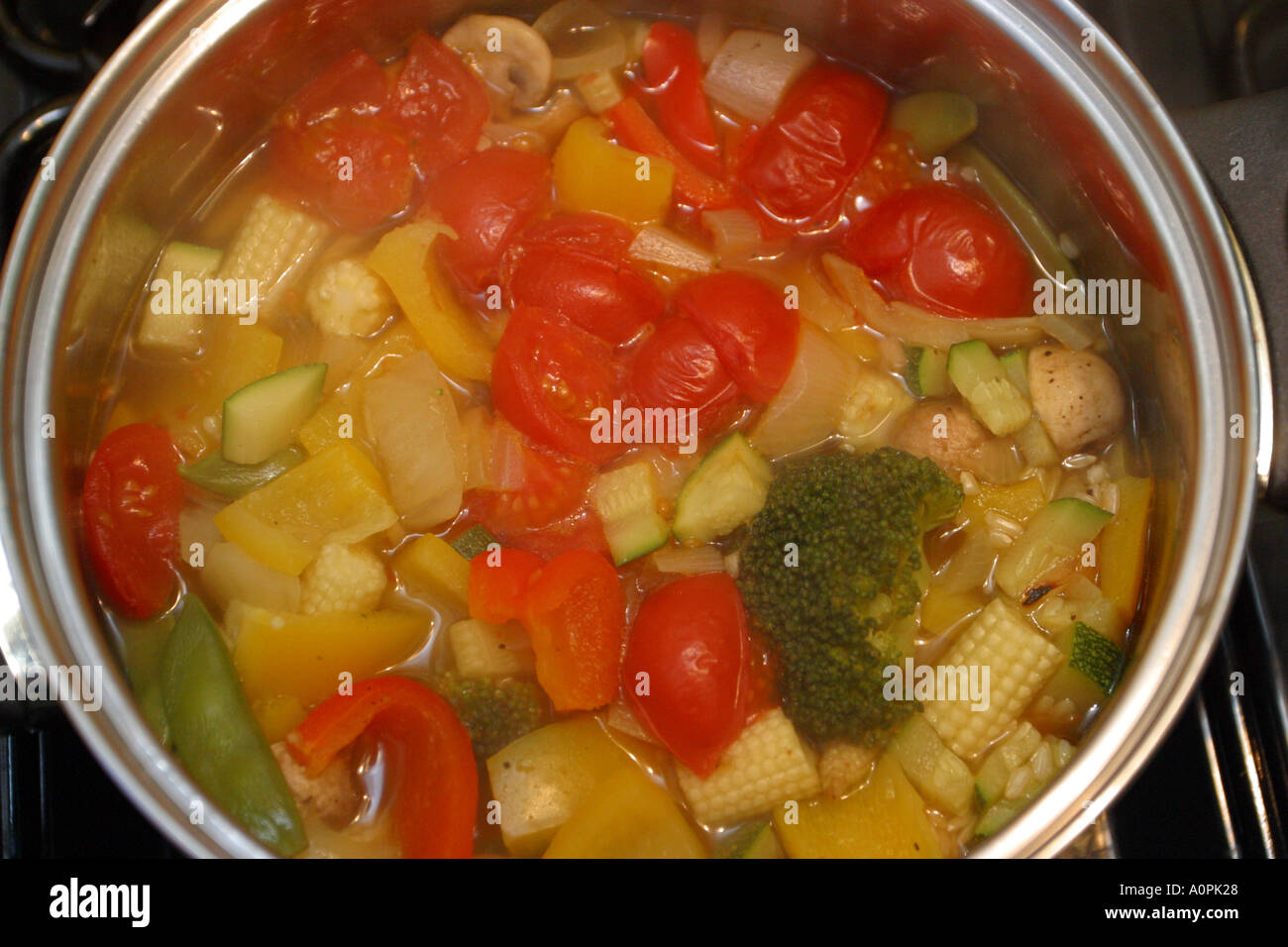 Mélange de légumes frais cuisinés comme étant un ragoût dans une casserole sur une cuisinière Banque D'Images