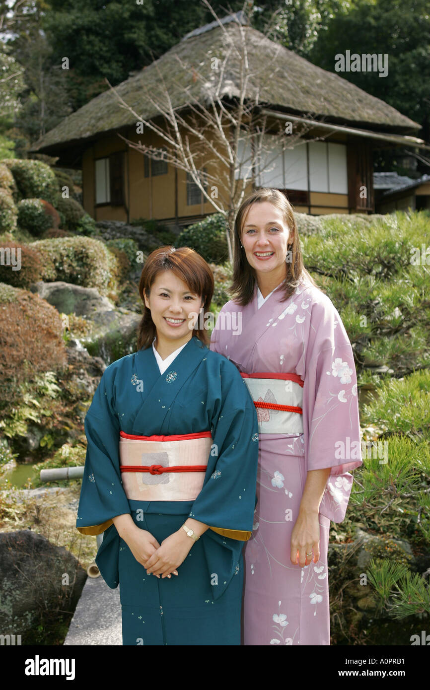 Femme japonaise avec western ami poser dans un jardin japonais à la fois porter le costume national de kimonos traditionnels en Asie Japon Kyoto Banque D'Images