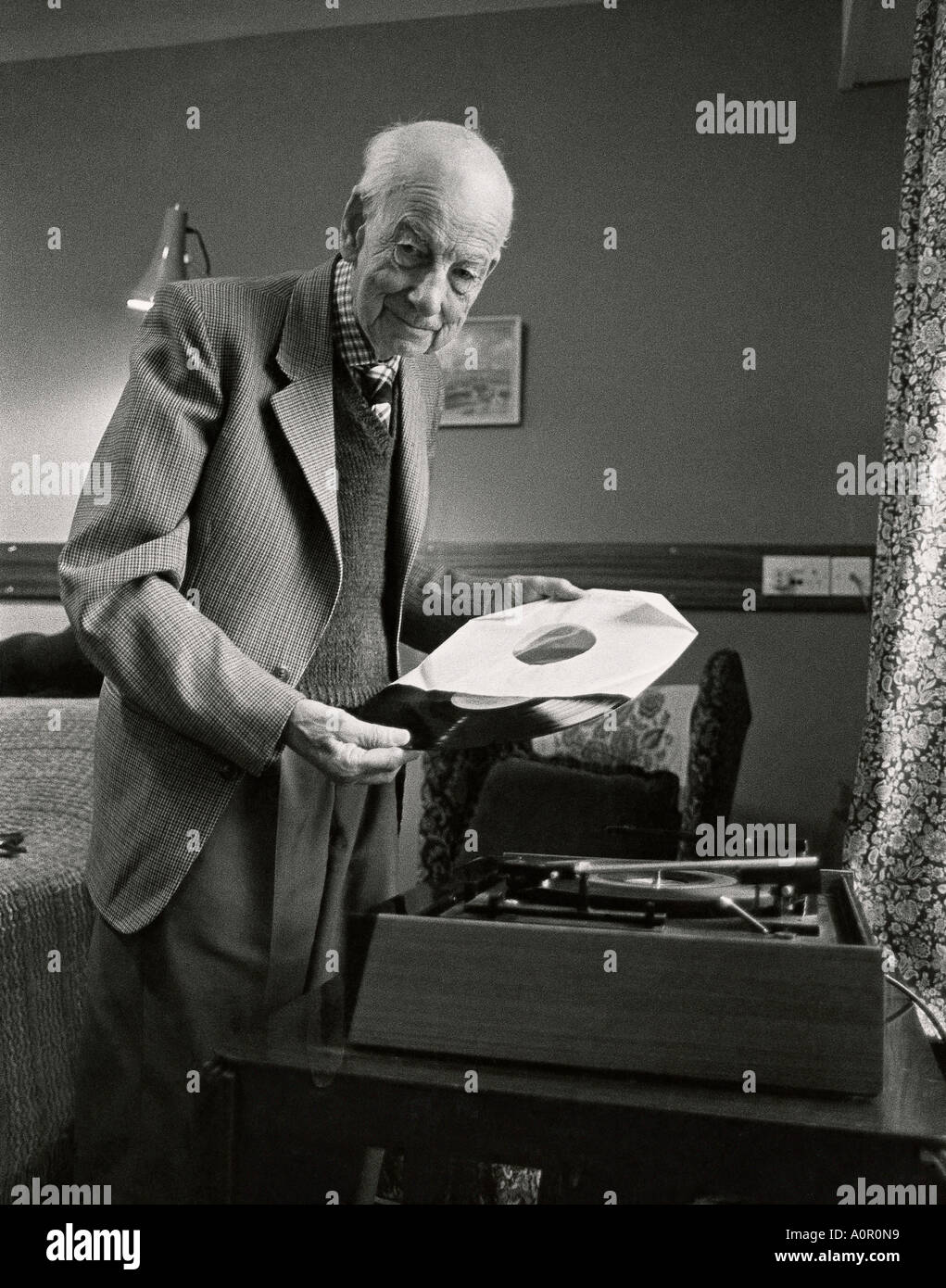 Un homme âgé à l'intérieur avec de vieux gramophone et enregistrement. Banque D'Images
