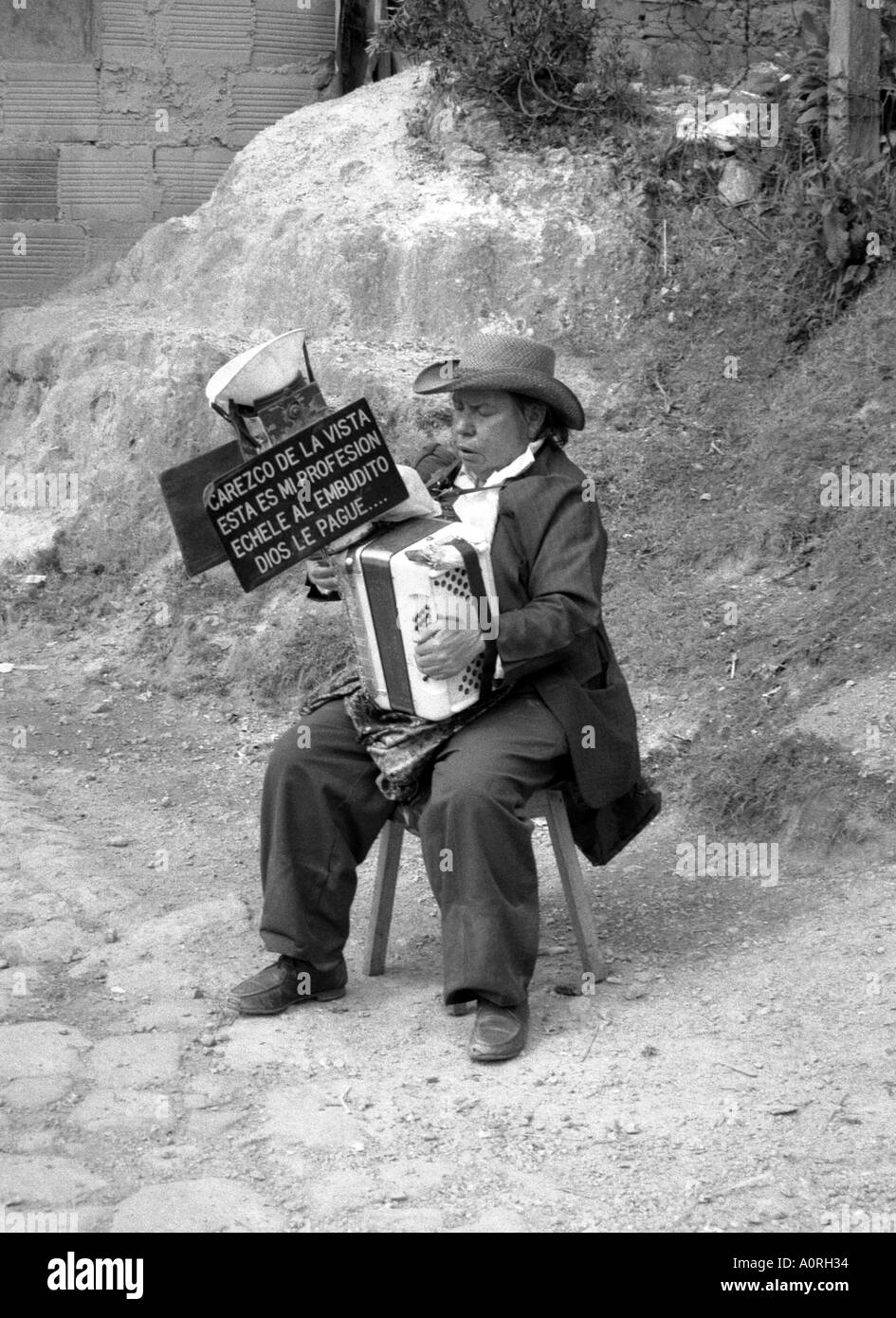 'Foi' artiste de rue homme jouant et collecter de l'argent dans l'entonnoir sur le dessus de son accordéon Bogota Colombie Amérique Latine du Sud Banque D'Images