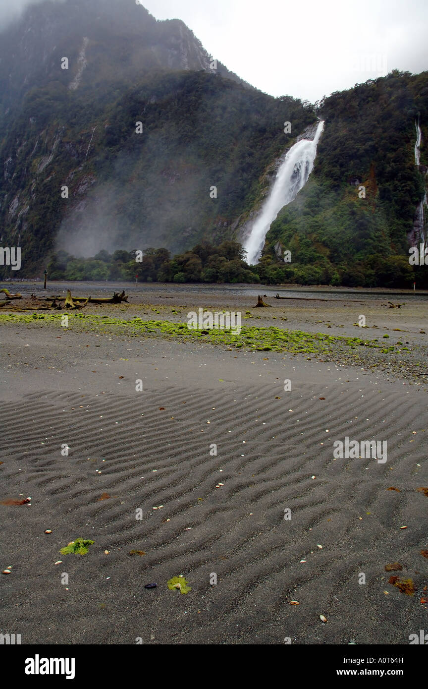 Bowen Falls et de sable à marée basse Milford Sound Parc National de Fiordland Nouvelle Zélande Banque D'Images