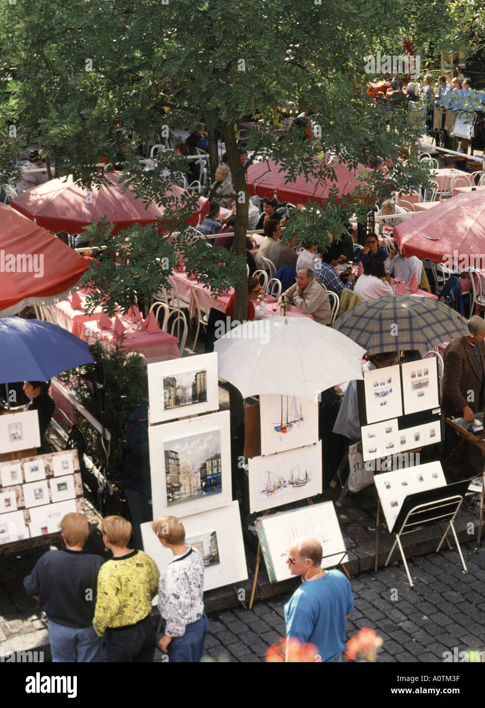 Paris Place du Tertre Montmartre Artistes trimestre avec imprimer s'affiche en compétition pour l'espace avec bar extérieur et tables de restaurant Banque D'Images