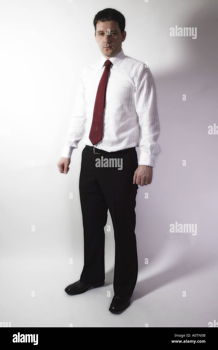 Homme debout en chemise et cravate avec confiance à l'appareil photo Banque D'Images