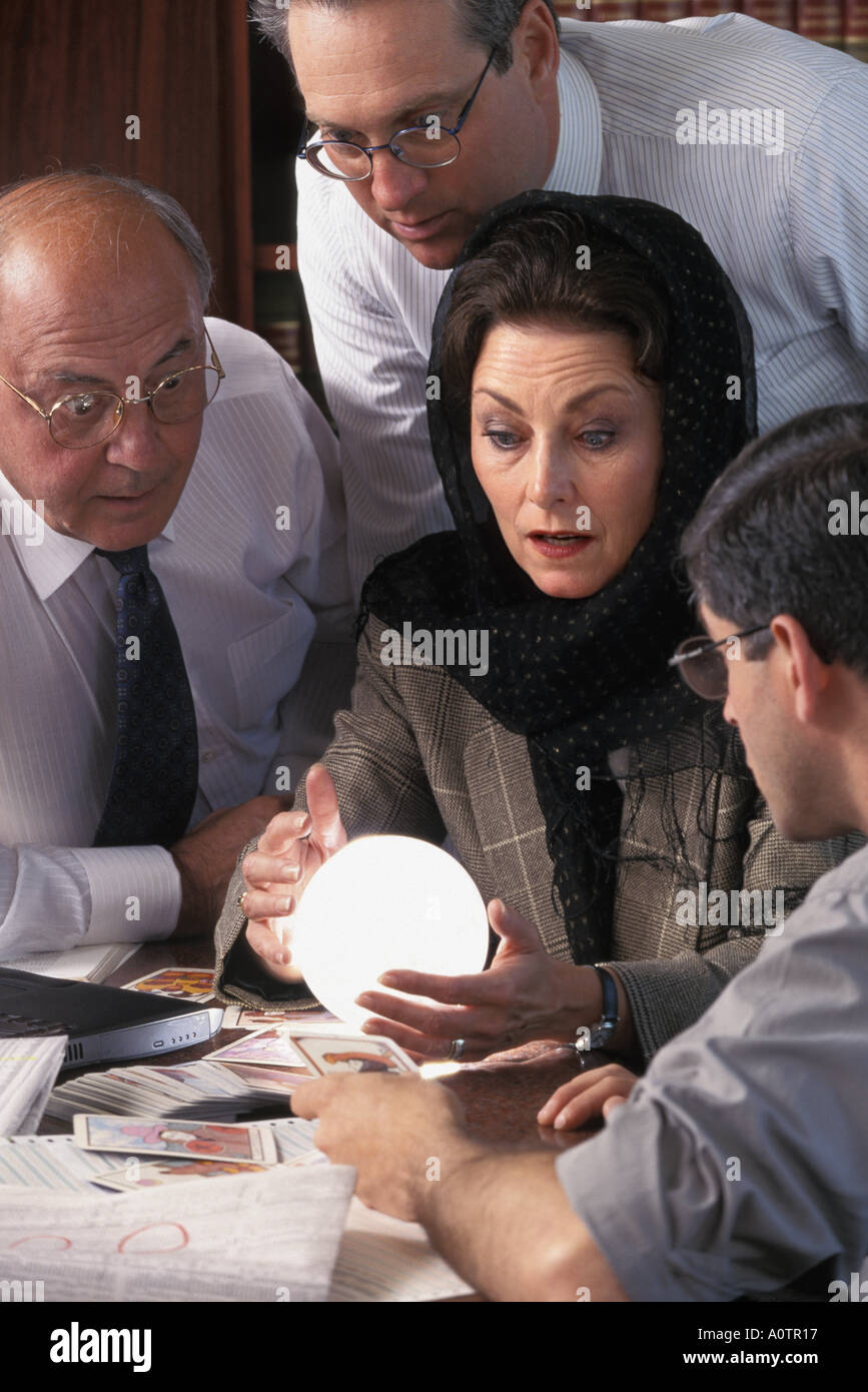 Les hommes d'affaires à la recherche de l'avenir à l'aide d'une boule de cristal et d'une diseuse Banque D'Images