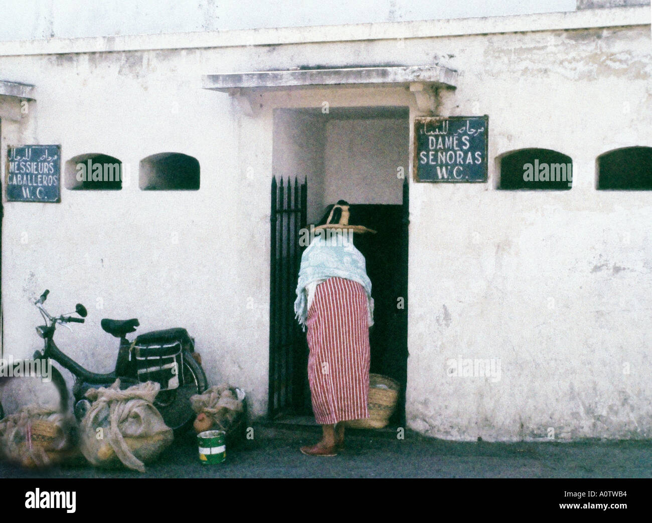 Afrique MAROC TANGER Berbère marocaine femme en costume traditionnel d'entrer les femmes s toilette publique, des signes en Arabe Français Banque D'Images