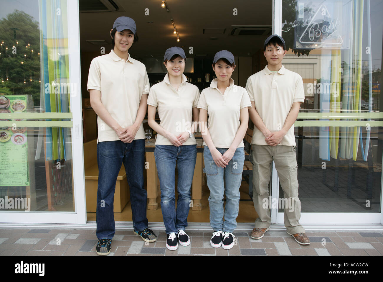 Portrait de deux serveurs avec deux serveuses debout en face d'un restaurant Banque D'Images