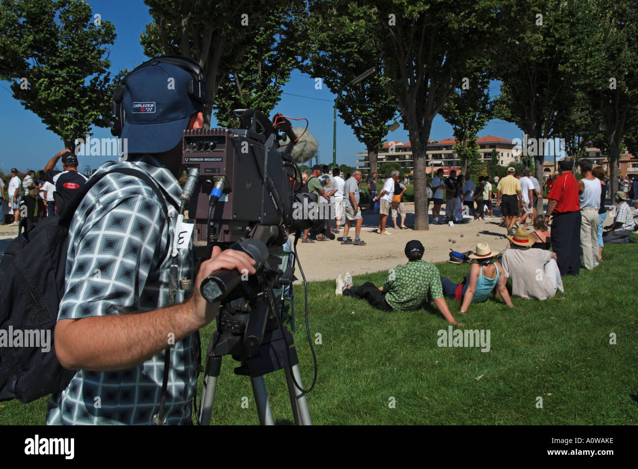 Caméraman de télévision régionale française prend un groupe de personnes qui jouent de la pétanque dans le Parc Borély, Marseillaise, France. Banque D'Images