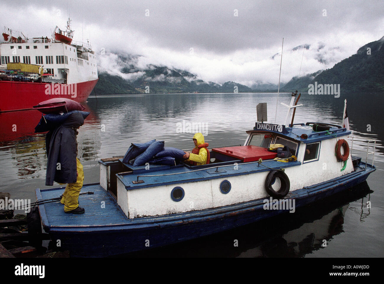 La charge de travail des hommes d'un petit bateau sur une calme inlet en Patgonia chilien Banque D'Images