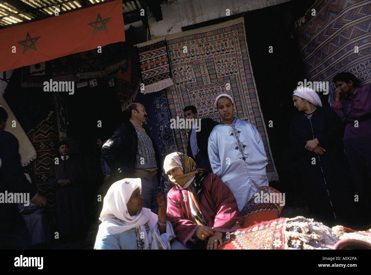 Les hommes et les femmes dans des châles et vêtements de mousseline au marché du tapis de Rabat Maroc Banque D'Images