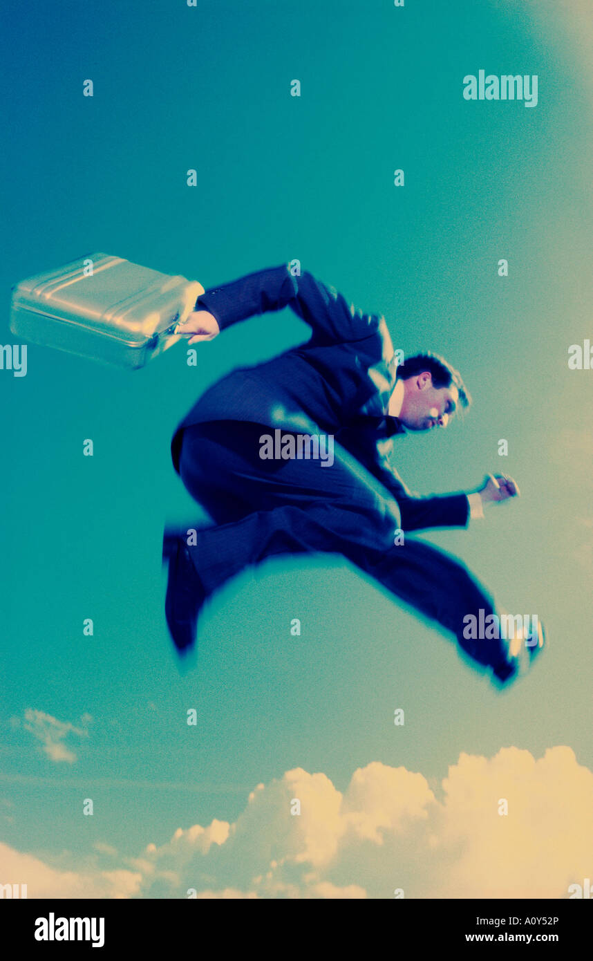 Low angle view of a businessman carrying a briefcase in mid-air Banque D'Images