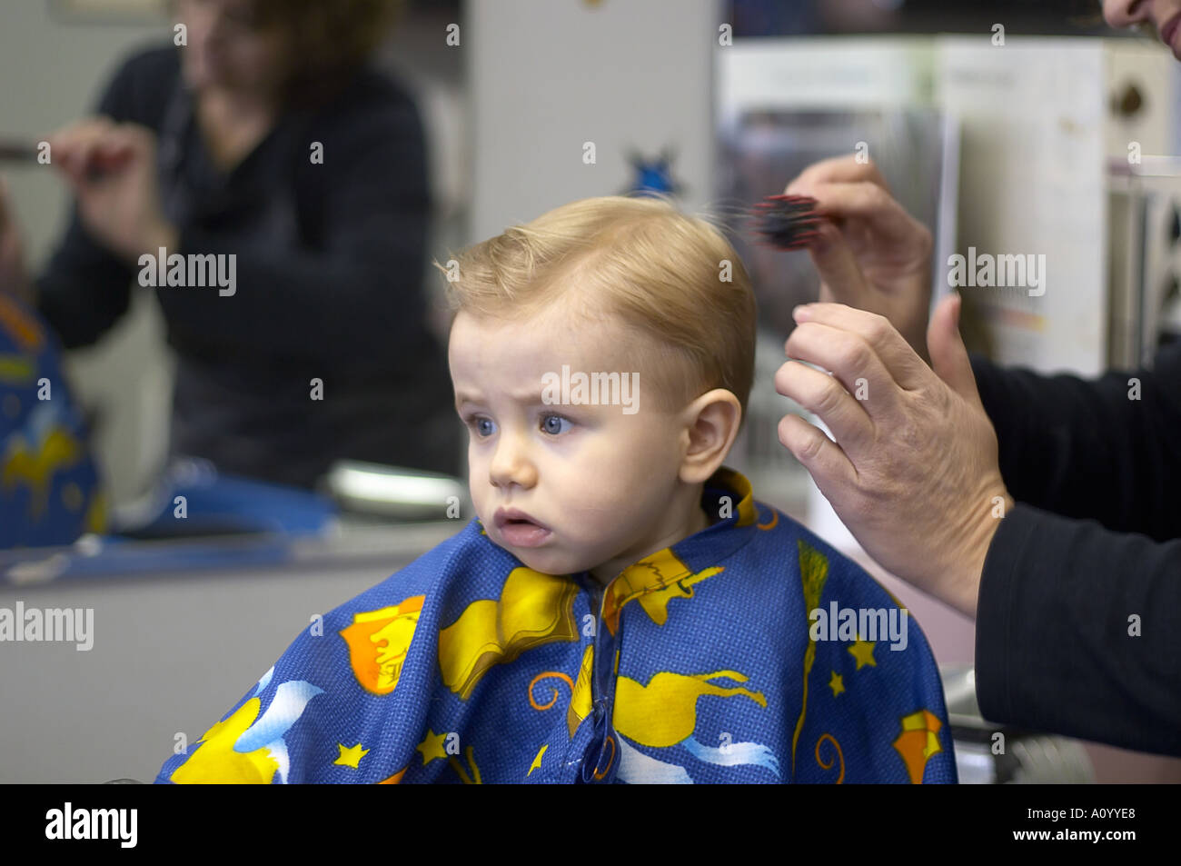 Un An Garcon Est Assis En Coiffure De Selles Pour La Premiere Coupe Modele Tout Petit Est Floue Parution Femme En Miroir N Est Pas De Droit Fils Yout Photo Stock Alamy
