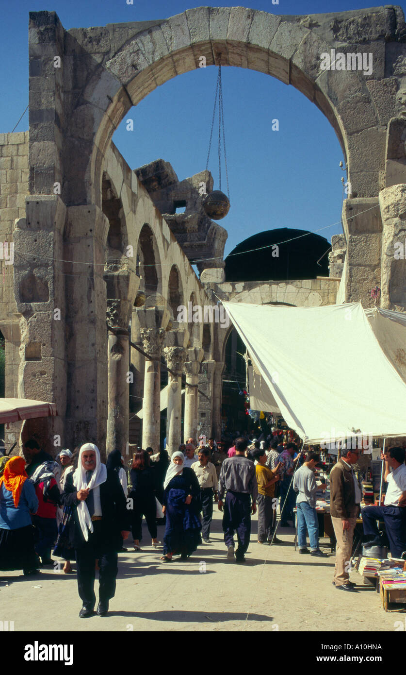 Le souk de la vieille ville de Damas Syrie Hamadyeh marché reste du temple de Jupiter porte ouest vue avec les gens marcher dans la verticale Banque D'Images