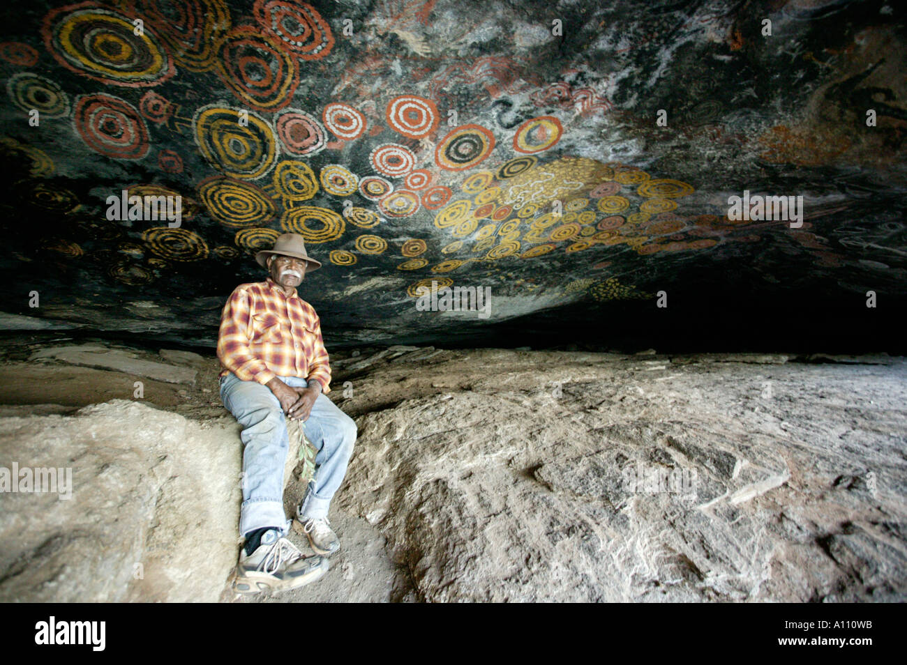 Un Autochtone et les peintures antiques de ses ancêtres terres Pitjantjara Anangu Cave HIll Australie du Sud Banque D'Images
