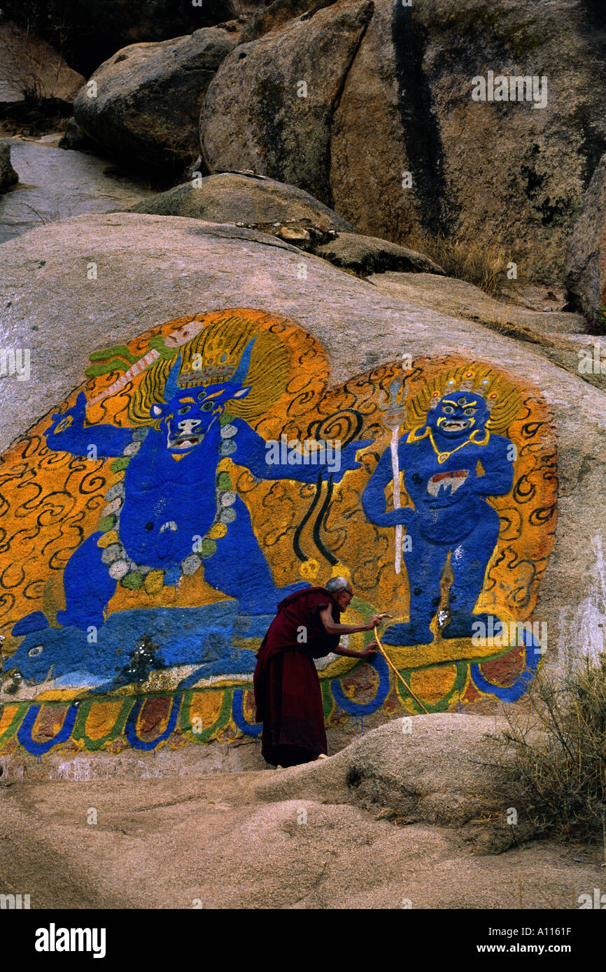 Monk walking par peinture rupestre monastère de Séra Lhassa au Tibet Chine Banque D'Images