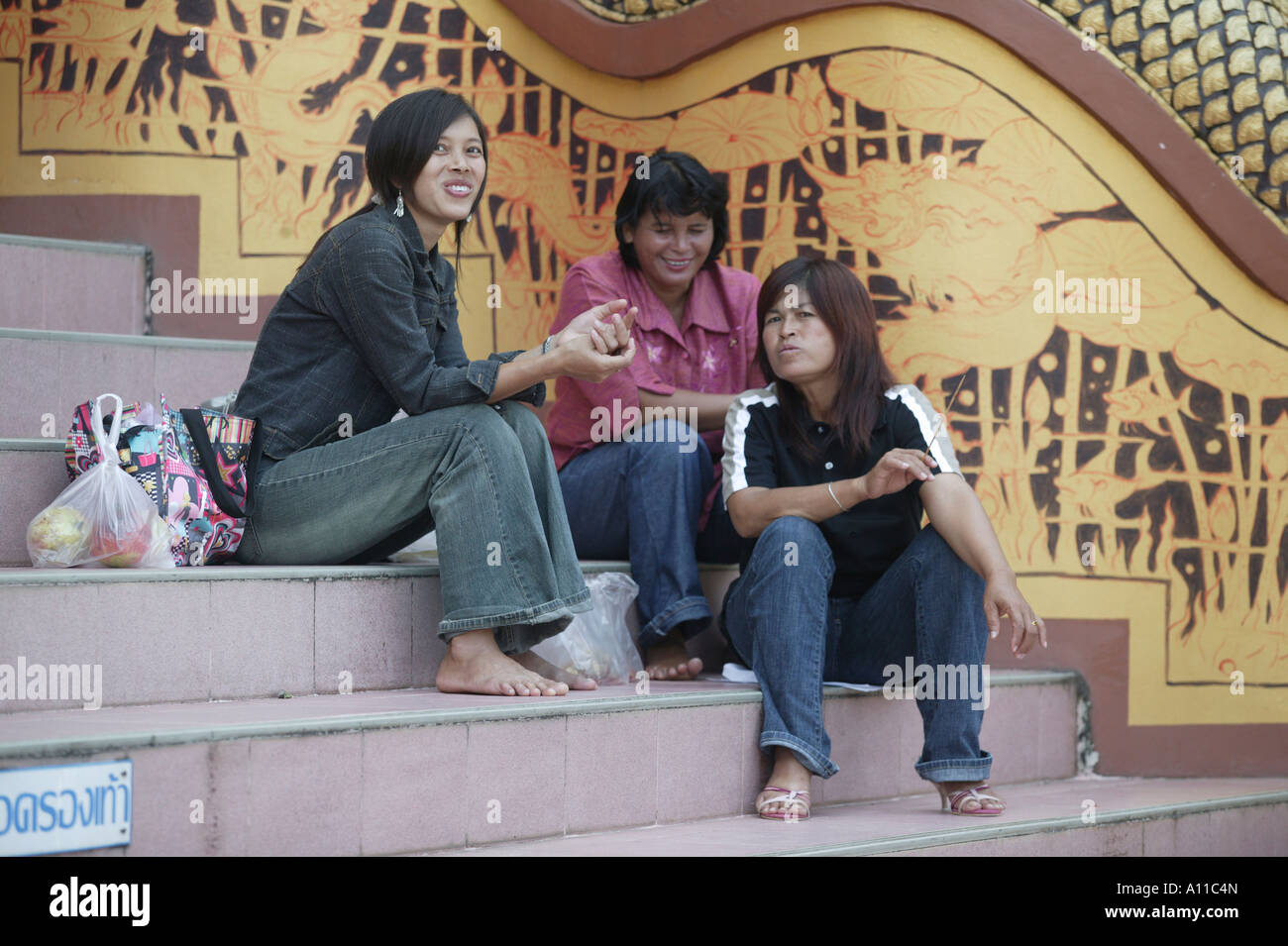 Trois filles le déjeuner sur les marches à l'Wat Phra That Doi Wao temple qui a été construit pour contenir des brins de cheveux de Bouddha s'il a été construit en 179 B C'est est donc un des plus anciens sanctuaires en mai Sai Banque D'Images