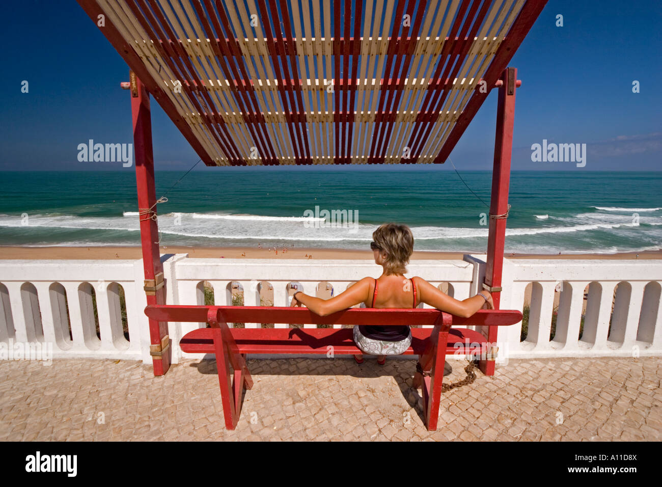 Jeune femme à rêver et à regarder l'Atlantique(Portugal). Jeune femme rêvant et contemplant l'Atlantique (Portugal). Banque D'Images