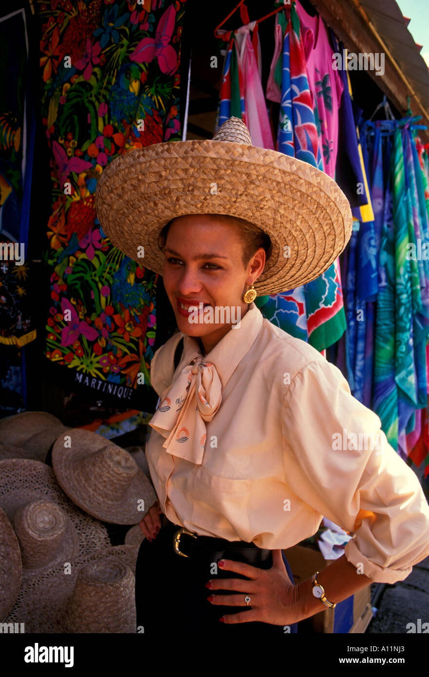 Femme martiniquais, shopper, essayant de chapeau de paille, marché artisanal, Place de la Savane, Fort-de-France, Martinique, French West Indies, France Banque D'Images