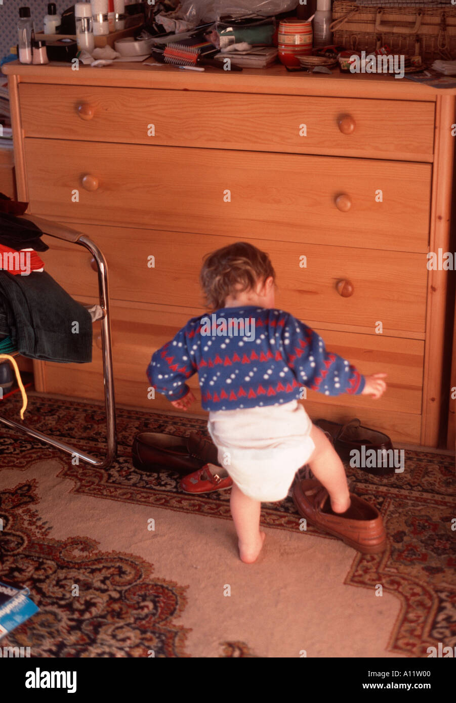 Petite fille tout-petit dans une couche couche droopy essayant sur un adulte  chaussure Photo Stock - Alamy