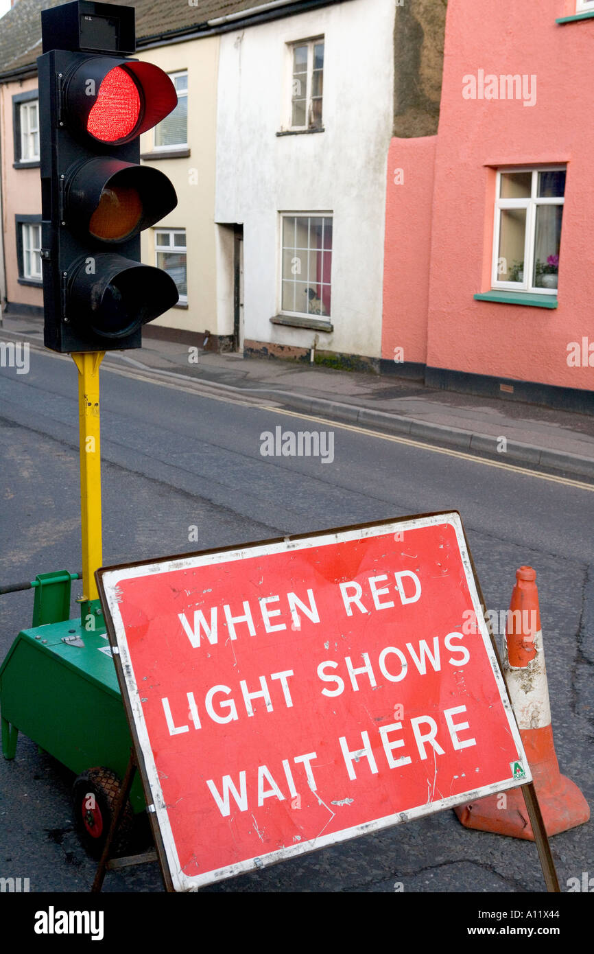 Au feu de circulation temporaire rouge avec 'quand red light show attendre ici' sur une route dans le Devon, Angleterre Banque D'Images