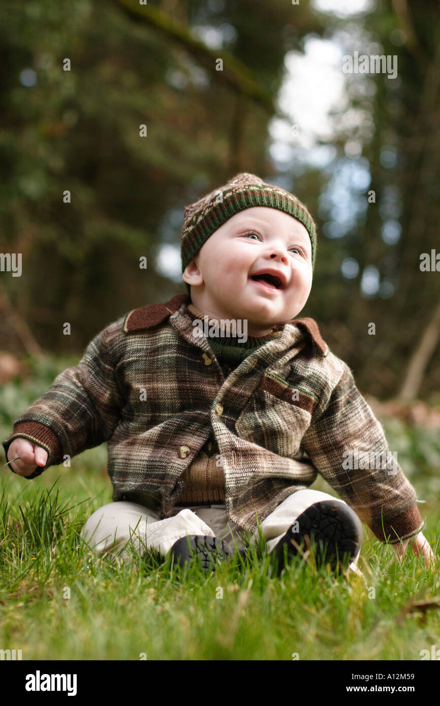 Bébé assis à l'extérieur dans l'herbe Banque D'Images