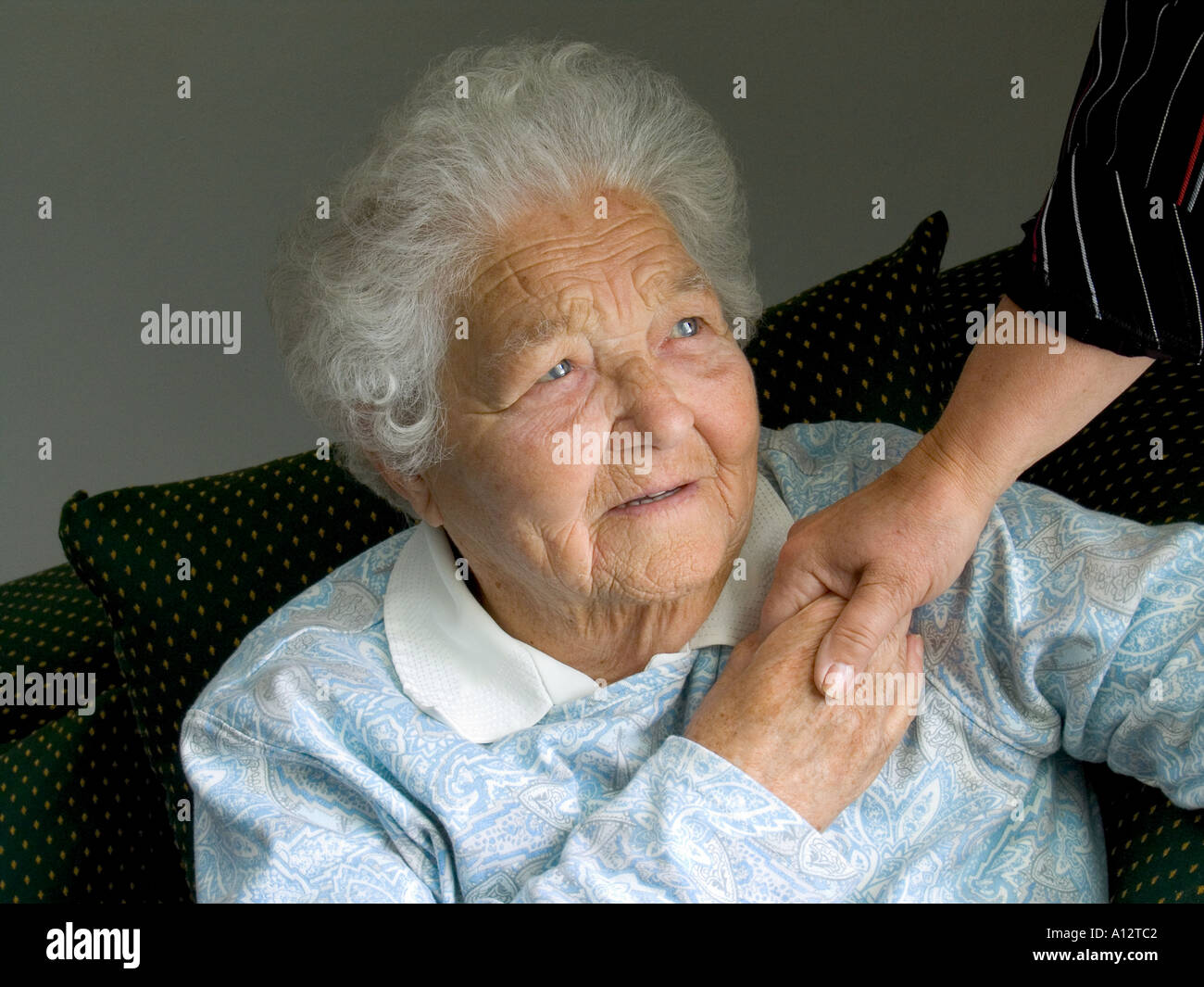 Indépendant satisfait personnes âgées senior lady détient main réconfortante d'infirmière soignant dans sa chambre la lumière naturelle intérieur horizontal Banque D'Images