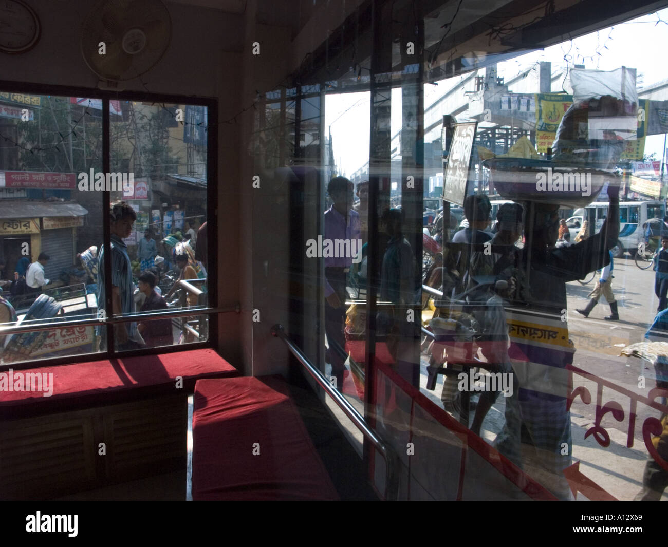 Le chaos de Dhaka urbain vu dans le reflet dans une vitrine Banque D'Images