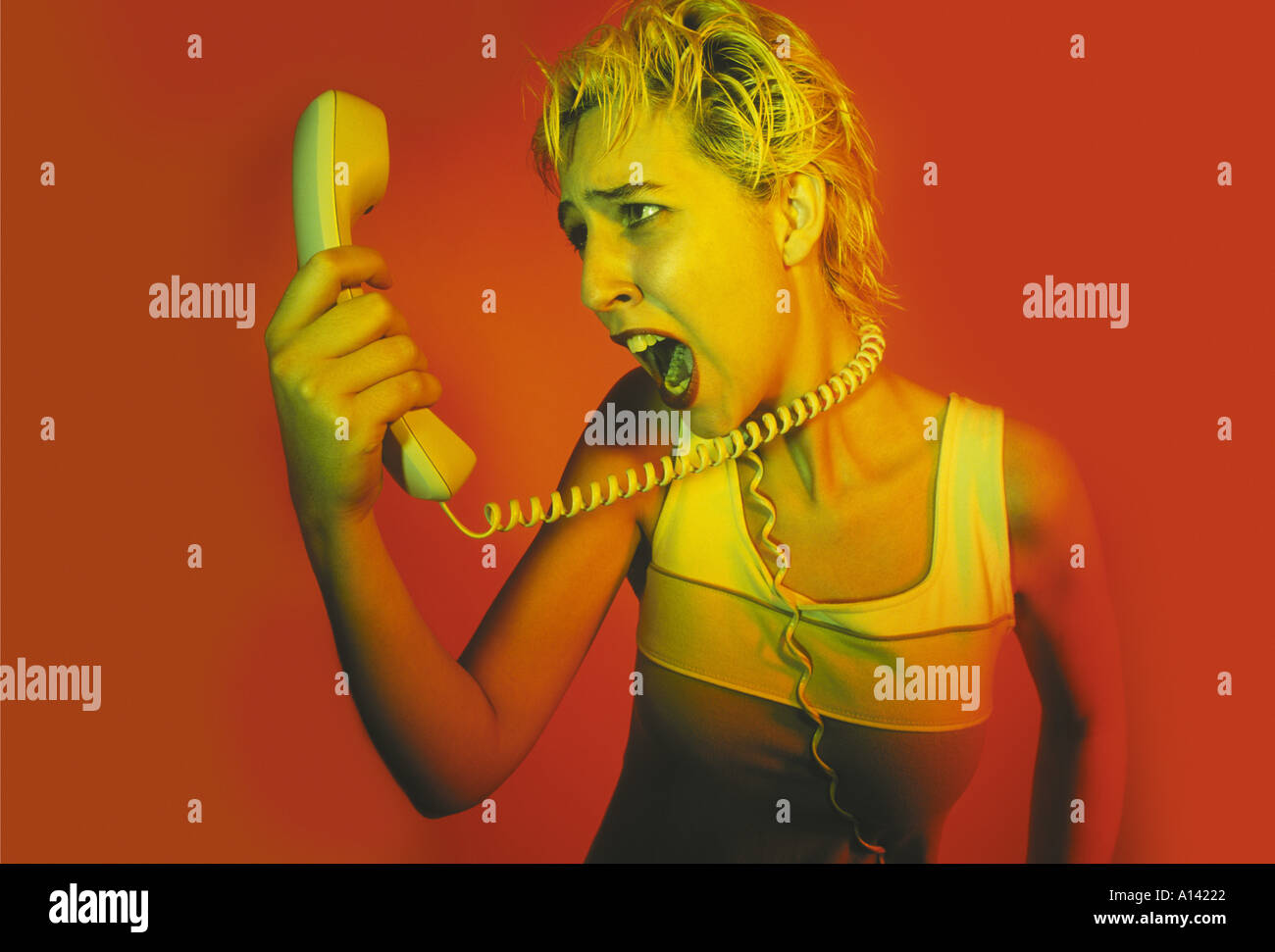 Femme EN COLÈRE FAISANT UN GESTE DE PARLER ET CRIER PAR TÉLÉPHONE Banque D'Images