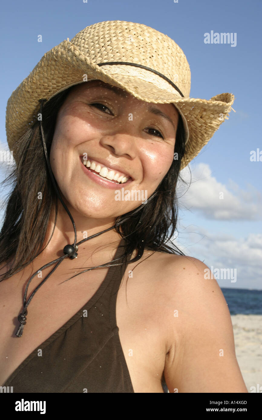jeune femme rousse bouclée joyeuse en veste en jean bleu et chapeau de  paille tenant une