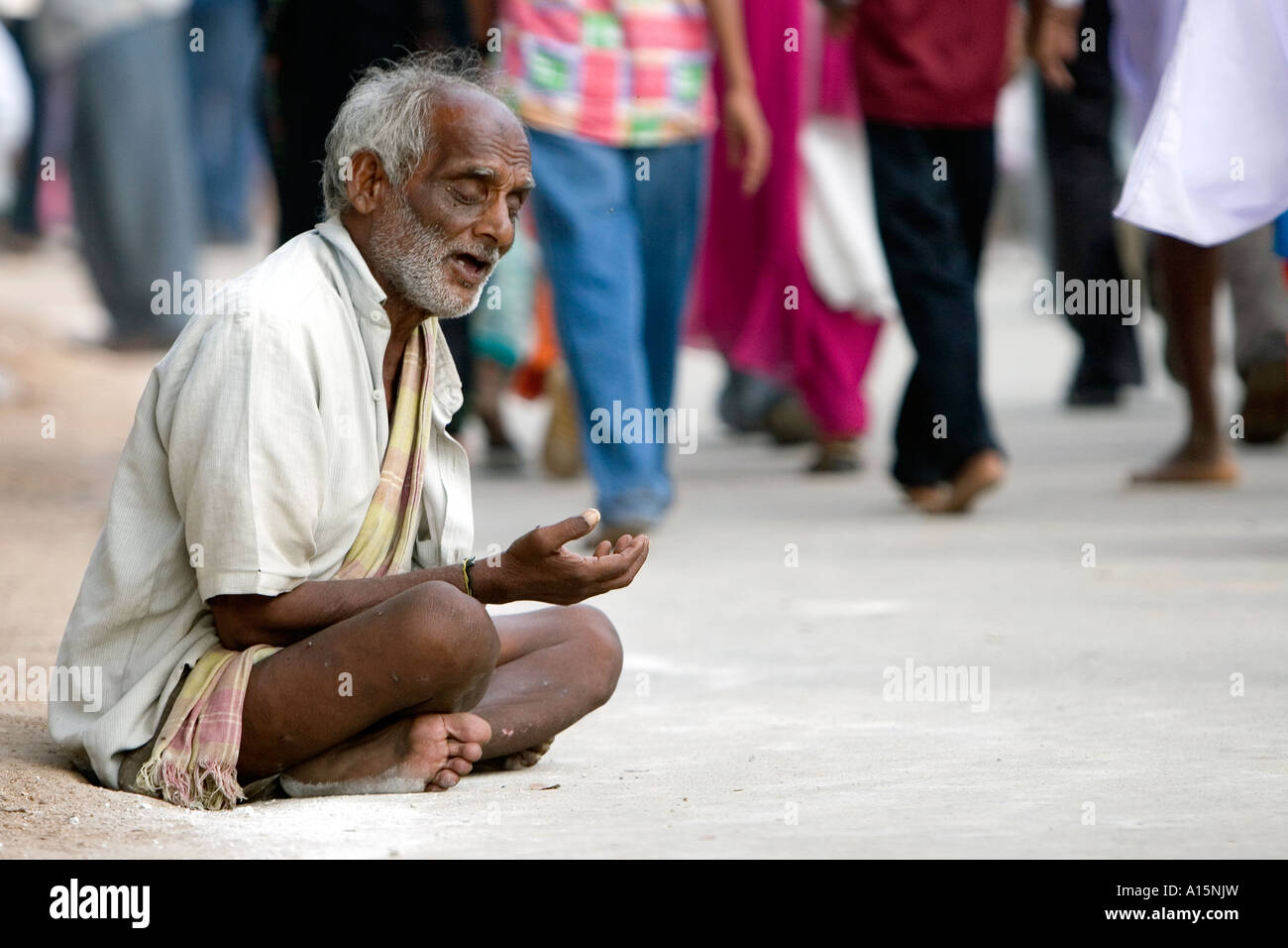 Ancien indien aveugle mendiant dans la rue devant un public. L'Andhra Pradesh, Inde Banque D'Images