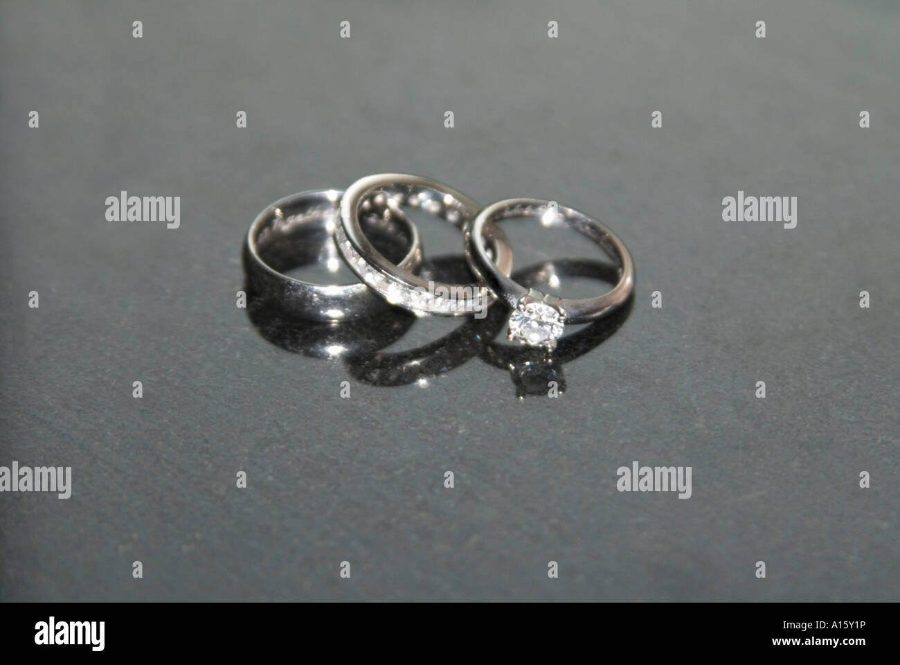 L'horizontale de près de l'époux et l'épouse et des bandes de mariage de platine du bride's bague de fiançailles en diamants sur un fond noir. Banque D'Images